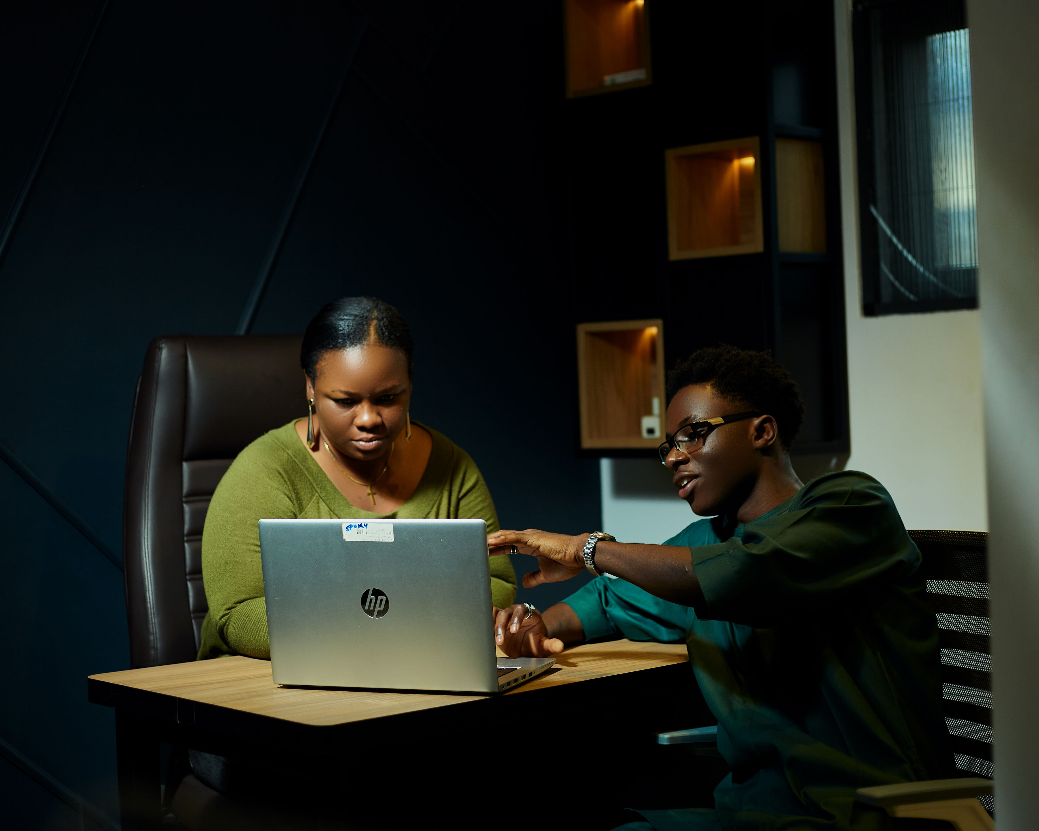 Colleagues collaborating over a design on a laptop